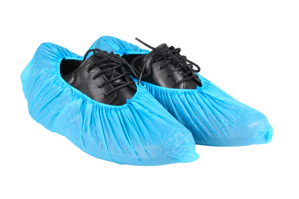 Black leather men's shoes in overshoes isolated on white background