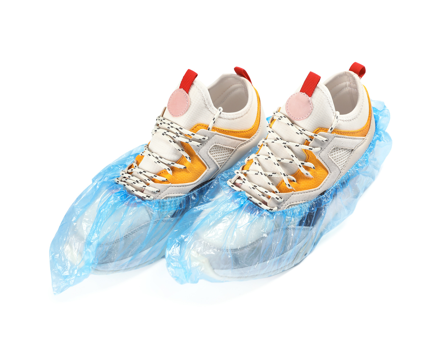 Pair of sneakers in medical blue covers on white background.