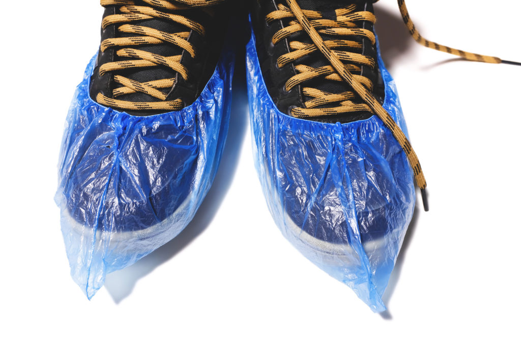 Daycare teacher shoes covered by plastic booties.