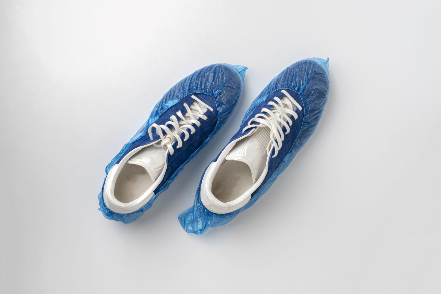 Blue and white sneakers inside shoe bootie covers.