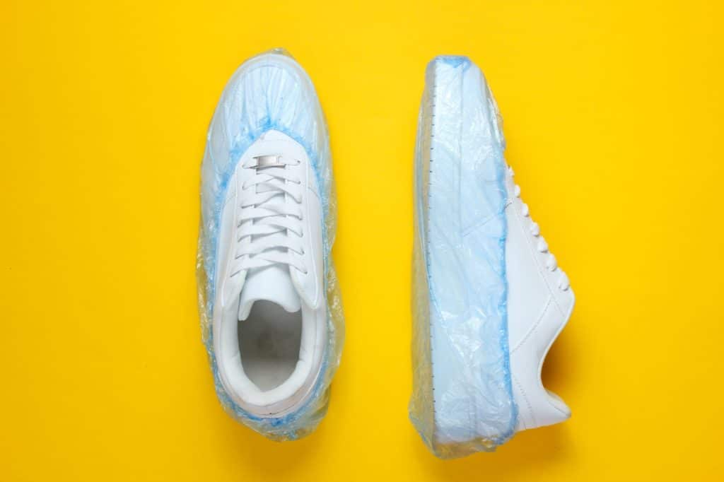 Tennis Shoes with protective plastic covers.