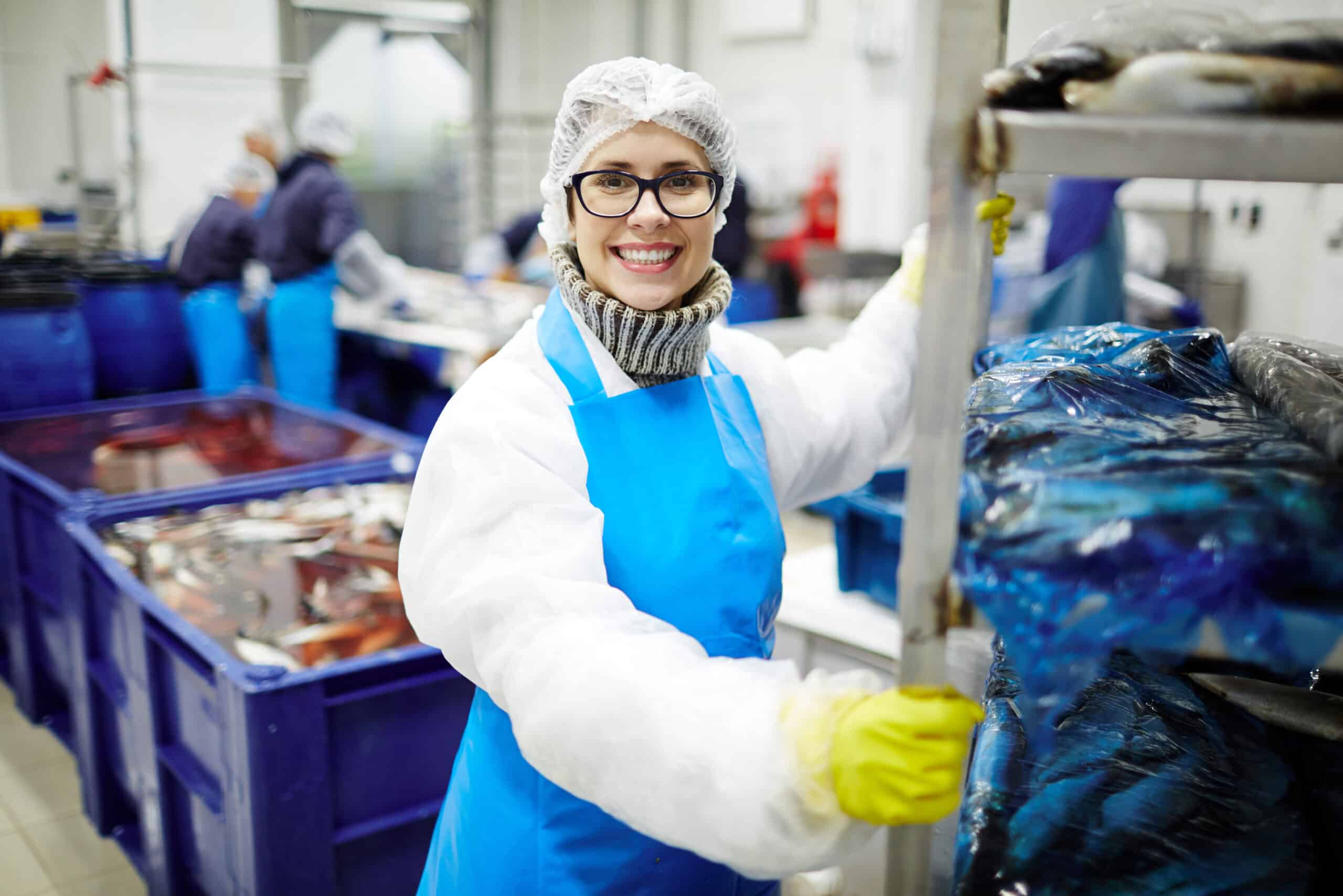 Food production line workers wearing protectie clothing for food sanitation